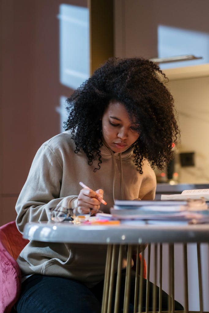 Girl Sitting at the Table with Textbooks and Studying